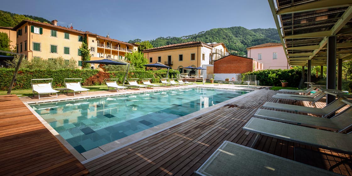 Grande piscine avec solarium et chaises longues au Park Hotel Regina